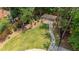 Lush backyard featuring a stone path leading to a charming pergola, surrounded by trees and manicured lawn at 735 River Ridge Ln, Suwanee, GA 30024