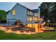 Beautiful backyard featuring a deck, patio with a fire pit, and manicured landscaping with accent lighting at 735 River Ridge Ln, Suwanee, GA 30024