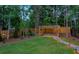 Serene backyard with a wooden pergola, lush lawn, and charming stone pathway leading to a seating area at 735 River Ridge Ln, Suwanee, GA 30024