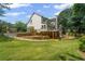 Expansive backyard with a deck, patio, lush lawn, and mature trees at 735 River Ridge Ln, Suwanee, GA 30024