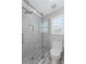 Modern bathroom showcasing a glass-enclosed shower with marble tiling, a new toilet, and mosaic tile floor at 735 River Ridge Ln, Suwanee, GA 30024