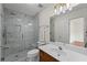 Modern bathroom showcasing a glass enclosed shower with marble tiling, a new toilet, and vanity with marble countertop at 735 River Ridge Ln, Suwanee, GA 30024