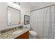 Bathroom features a granite countertop vanity, framed mirror, and a shower with patterned curtain at 735 River Ridge Ln, Suwanee, GA 30024