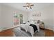 Cozy bedroom with a ceiling fan, hardwood floors, large window, and a comfortable bed at 735 River Ridge Ln, Suwanee, GA 30024