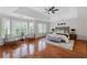 Bright main bedroom with tray ceiling, sitting area, hardwood floors, and large windows offering natural light at 735 River Ridge Ln, Suwanee, GA 30024