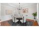 Dining room with modern chandelier, round glass table, wainscoting, and hardwood floors at 735 River Ridge Ln, Suwanee, GA 30024