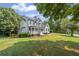 A two-story home with a white exterior, dark shutters, and a well-manicured lawn at 735 River Ridge Ln, Suwanee, GA 30024