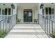 Elegant front entrance with black double doors, white brick, and beautiful landscaping at 735 River Ridge Ln, Suwanee, GA 30024
