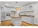 Bright kitchen with granite countertops, white cabinetry, and a central island with pendant lighting at 735 River Ridge Ln, Suwanee, GA 30024
