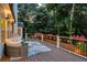 Cozy outdoor deck featuring comfortable seating, string lights, and tranquil views of the surrounding trees at 735 River Ridge Ln, Suwanee, GA 30024