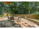 Stone patio with seating area, landscaping, and a wooden fence at 735 River Ridge Ln, Suwanee, GA 30024