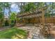Outdoor patio with a pergola, bench seating, string lights, and landscaping at 735 River Ridge Ln, Suwanee, GA 30024