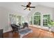 Sunroom featuring hardwood floors, vaulted ceiling, oversized windows, seating area and ceiling fan at 735 River Ridge Ln, Suwanee, GA 30024