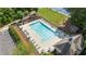 Aerial view of a fenced community pool with lounge chairs and a picnic area near a clubhouse and playground at 735 River Ridge Ln, Suwanee, GA 30024