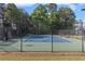 Outdoor fenced tennis court and basketball court with lighting for evening play at 735 River Ridge Ln, Suwanee, GA 30024