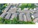 Aerial view of townhomes featuring two car garages, a community pool, and lush landscaping in a thriving community at 747 Topsail Ln, Alpharetta, GA 30005