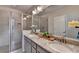 Bathroom featuring double sinks, granite countertops, and a glass shower at 747 Topsail Ln, Alpharetta, GA 30005