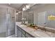 Modern bathroom with double sinks, granite countertop, framed mirrors and glass shower enclosure at 747 Topsail Ln, Alpharetta, GA 30005