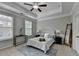 This bedroom features a tray ceiling, ceiling fan, a padded headboard, and a blue rug at 747 Topsail Ln, Alpharetta, GA 30005
