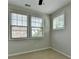 Bright bedroom featuring two windows offering natural light and neutral carpeting at 747 Topsail Ln, Alpharetta, GA 30005