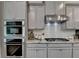 Modern kitchen with built-in ovens, subway tile backsplash, and stainless steel appliances at 747 Topsail Ln, Alpharetta, GA 30005