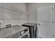 Modern laundry room features a washer, dryer, and shelving for storage at 747 Topsail Ln, Alpharetta, GA 30005