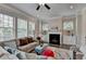 Bright living room features a fireplace, ceiling fan, and built-in cabinets flanked by windows at 747 Topsail Ln, Alpharetta, GA 30005