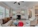 Bright living room features a fireplace, ceiling fan, and built-in cabinets flanked by windows at 747 Topsail Ln, Alpharetta, GA 30005