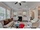 Bright living room features a fireplace, ceiling fan, and built-in cabinets flanked by windows at 747 Topsail Ln, Alpharetta, GA 30005