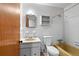 Bathroom featuring a tub, toilet, vanity, medicine cabinet, and classic white tile at 900 Fleetwood Cir, Atlanta, GA 30311