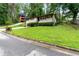 View of the brick ranch home with a lush green lawn on a sunny day at 900 Fleetwood Cir, Atlanta, GA 30311