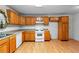 This kitchen features wood cabinets, white appliances, and functional layout at 900 Fleetwood Cir, Atlanta, GA 30311