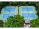 Aerial view showcasing two well-maintained tennis courts surrounded by lush greenery at 10645 Tuxford Dr, Alpharetta, GA 30022