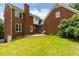 An expansive backyard featuring a lush lawn, mature trees, and a brick home exterior at 10645 Tuxford Dr, Alpharetta, GA 30022