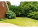 A picturesque backyard with well-maintained lawn, mature trees, and a lush garden area at 10645 Tuxford Dr, Alpharetta, GA 30022