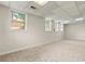 Spacious basement with carpet flooring, bright lighting, and multiple windows at 10645 Tuxford Dr, Alpharetta, GA 30022