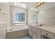 Bright bathroom with a soaking tub, skylight, and stained glass window, offering a spa-like experience at 10645 Tuxford Dr, Alpharetta, GA 30022