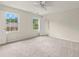 Spacious bedroom featuring a ceiling fan, neutral walls, and windows with views of the exterior at 10645 Tuxford Dr, Alpharetta, GA 30022