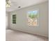A light and airy bedroom with a ceiling fan and large windows offering views of the neighborhood at 10645 Tuxford Dr, Alpharetta, GA 30022