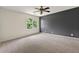 A bright bedroom with a large window providing natural light and a modern ceiling fan at 10645 Tuxford Dr, Alpharetta, GA 30022