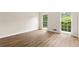Bright bedroom featuring newly installed hardwood floors and natural light from two windows at 10645 Tuxford Dr, Alpharetta, GA 30022