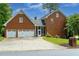 Charming two-story brick home featuring an attached garage, well-manicured lawn, and driveway at 10645 Tuxford Dr, Alpharetta, GA 30022