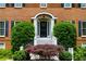 Close-up of the inviting front door, enhanced with lush landscaping and elegant architectural details at 10645 Tuxford Dr, Alpharetta, GA 30022