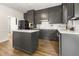 Elegant kitchen featuring gray cabinets, stainless steel appliances, and a center island with a white countertop at 10645 Tuxford Dr, Alpharetta, GA 30022