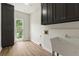 Functional laundry room with sink, storage cabinets, and a window for natural light at 10645 Tuxford Dr, Alpharetta, GA 30022