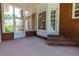 Enclosed porch with brick walling, carpeted floor and large windows providing natural lighting at 10645 Tuxford Dr, Alpharetta, GA 30022