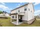 Grassy backyard featuring a covered patio, barbeque and two-story home at 1504 Lemon Balm Ct, Lawrenceville, GA 30045