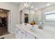 Modern bathroom featuring dual sinks, white countertops, and a glimpse into the glass-enclosed shower and walk-in closet at 1504 Lemon Balm Ct, Lawrenceville, GA 30045