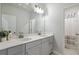 Bright bathroom with dual sinks and a large mirror, showcasing modern fixtures and a glimpse into the shower at 1504 Lemon Balm Ct, Lawrenceville, GA 30045