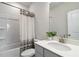 Bathroom with a tub and shower combination featuring a patterned curtain and sleek white finishes at 1504 Lemon Balm Ct, Lawrenceville, GA 30045